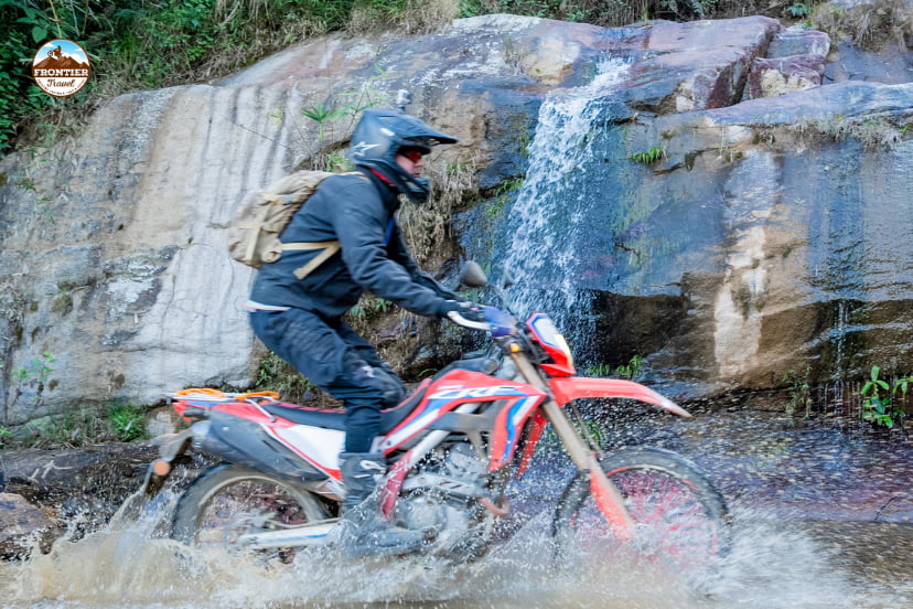 Motorbike rider maintaining balance and confidence on a challenging Vietnamese road